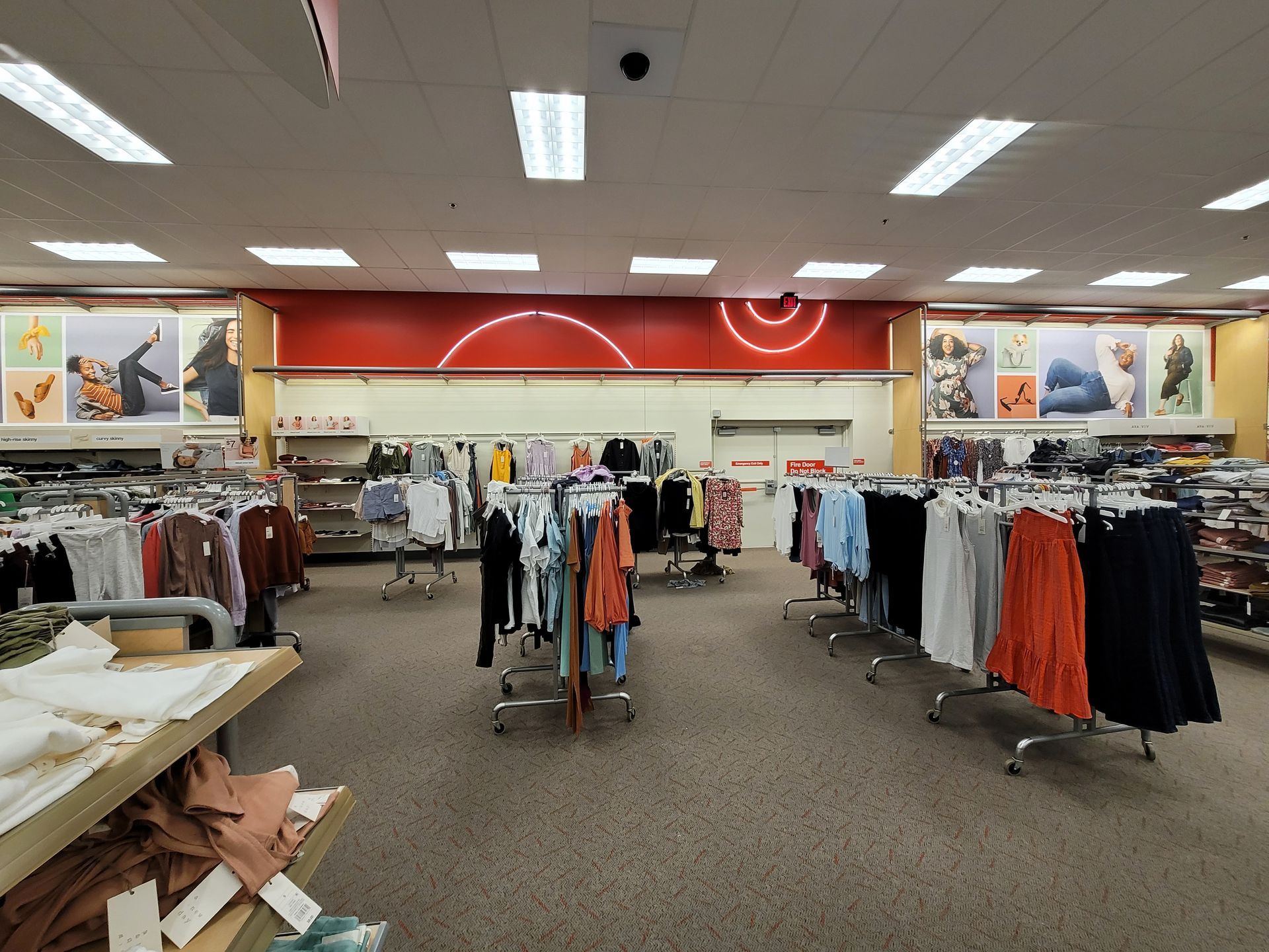 The inside of a clothing store with clothes hanging on racks.