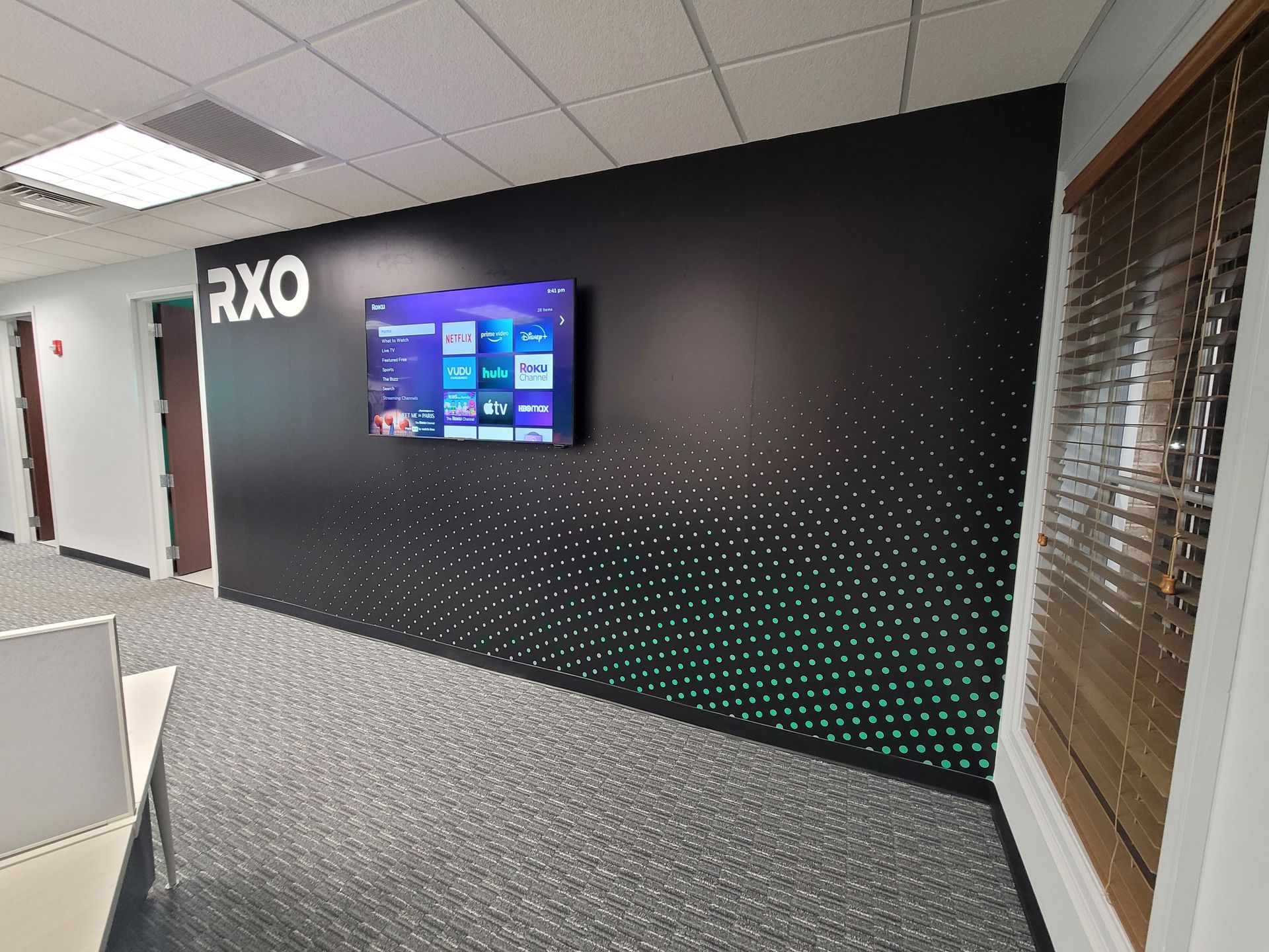 A tv mounted on a wall with the word rxo on it