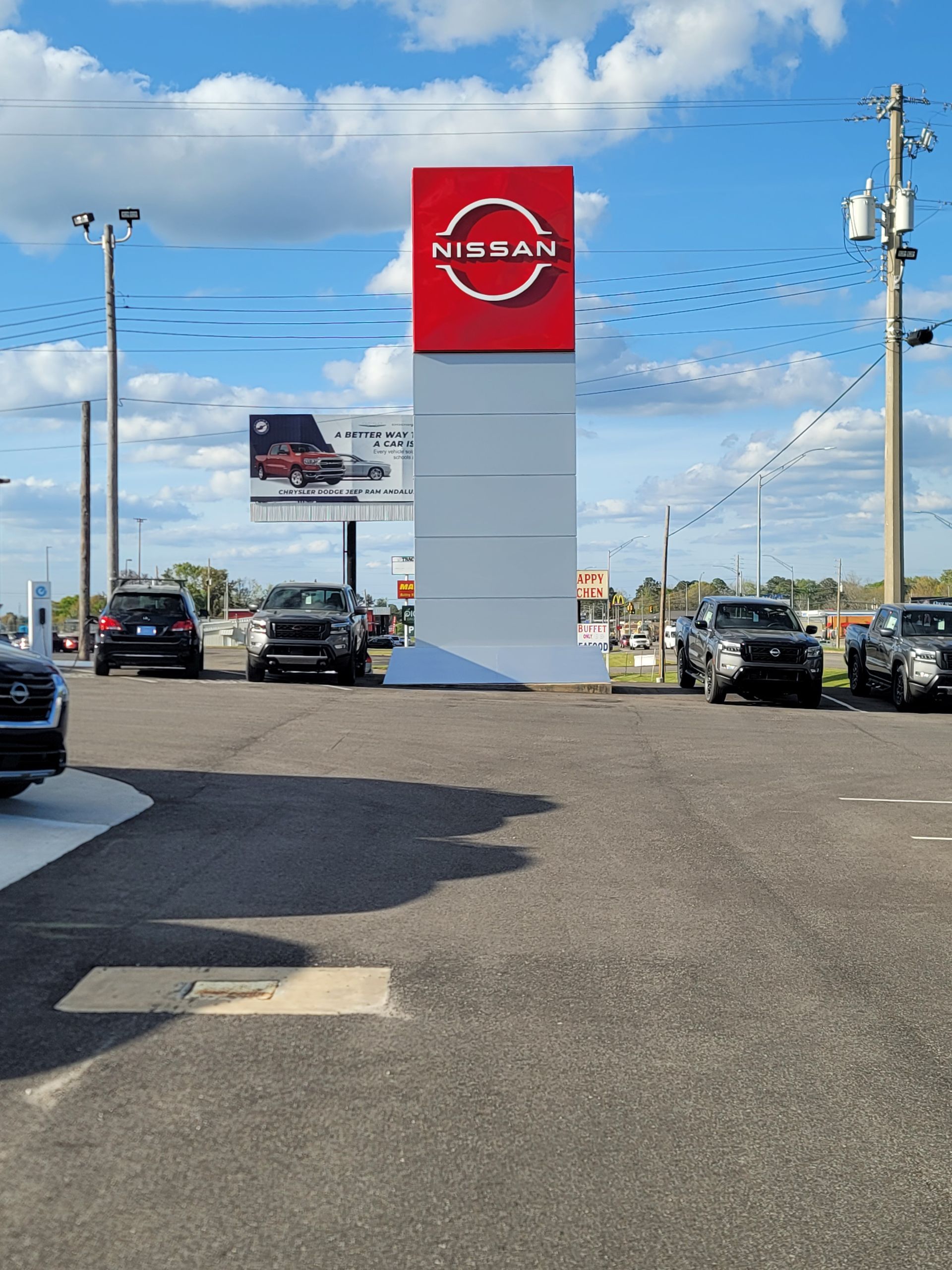 A nissan dealership with cars parked in front of it