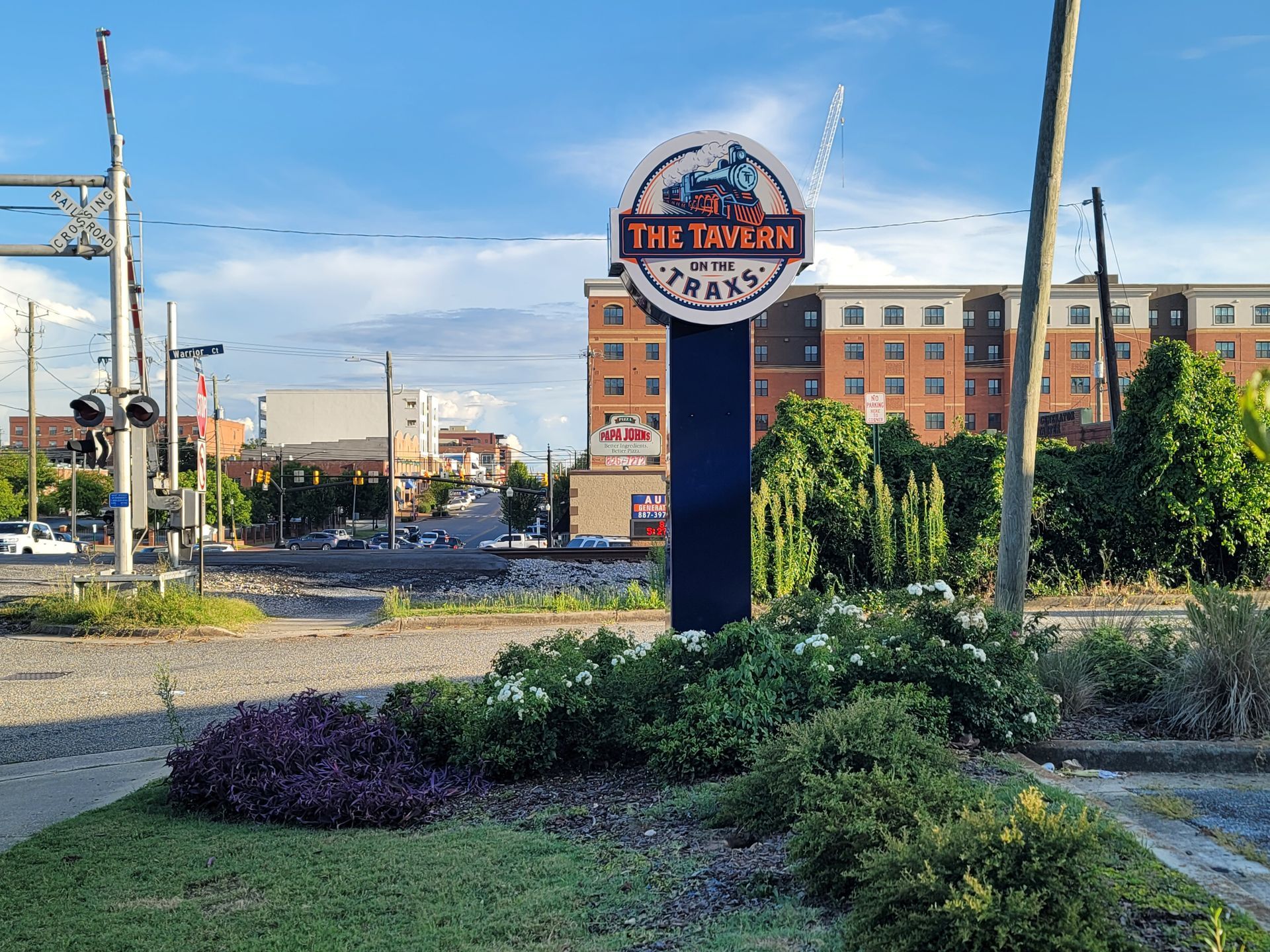 A sign for the tavern is sitting in the middle of a roundabout.