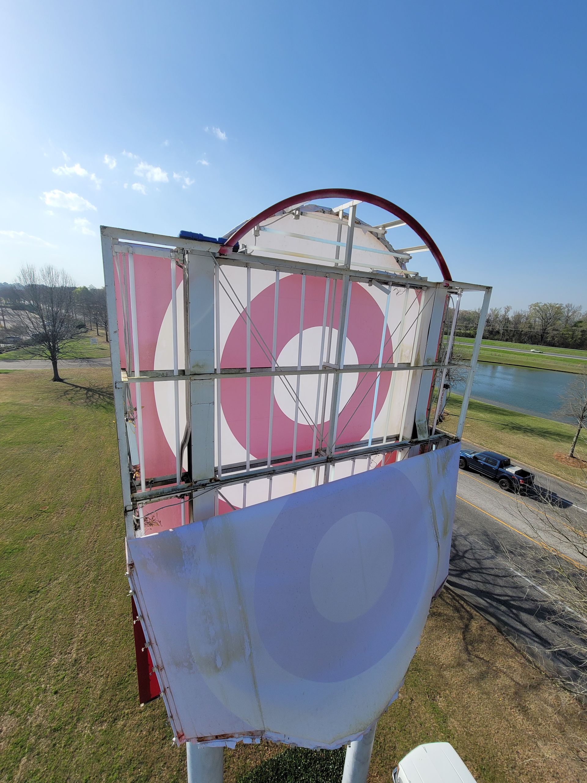 A frisbee golf basket is sitting on top of a grass covered field.