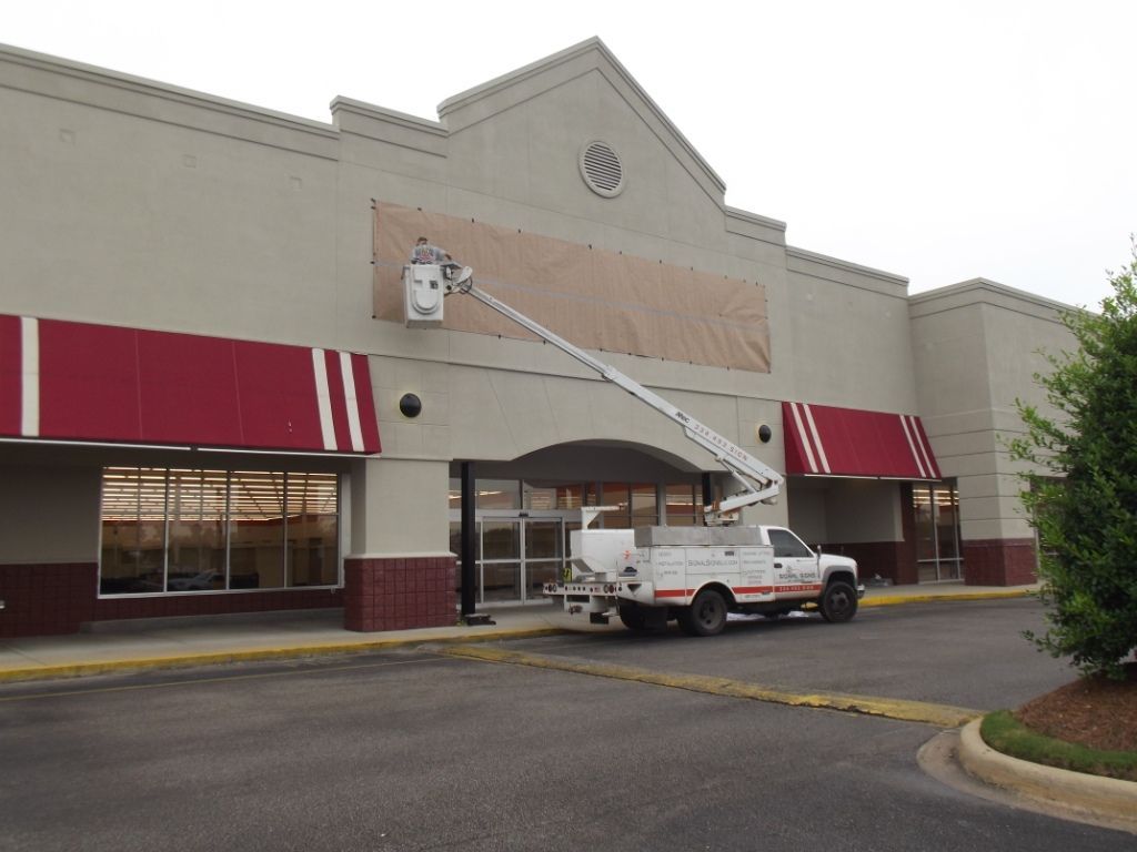 A white truck is parked in front of a building with red awnings