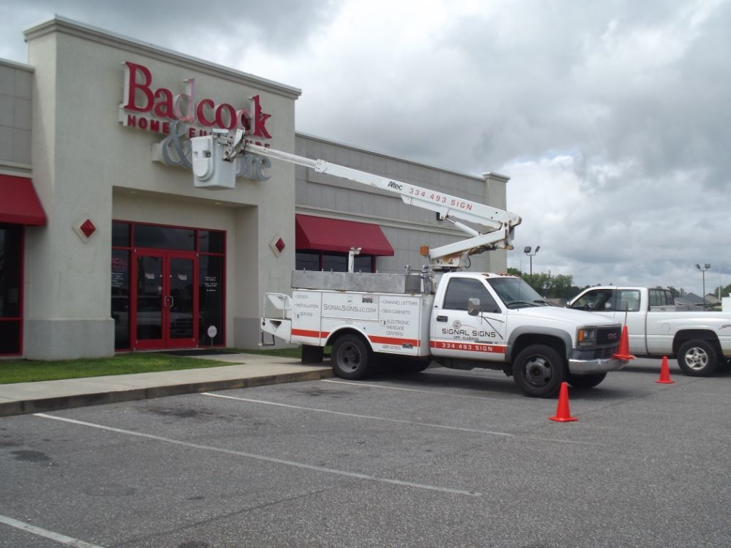A white truck is parked in front of a building that says ba cook