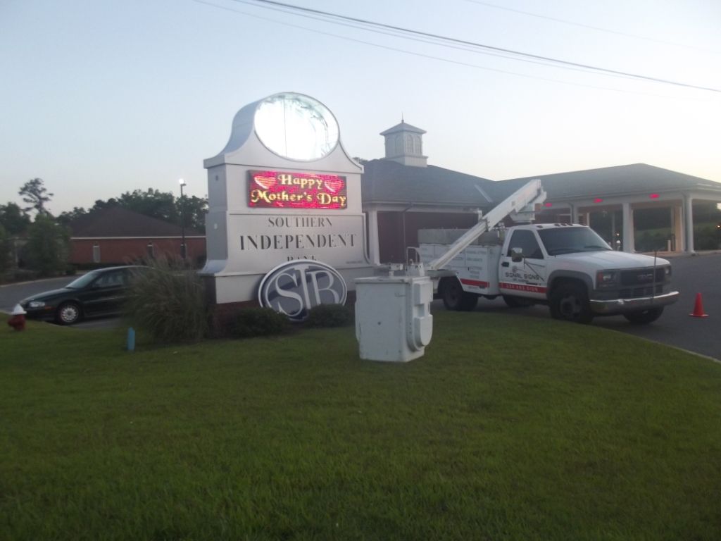 A white truck is parked in front of a sign that says independent