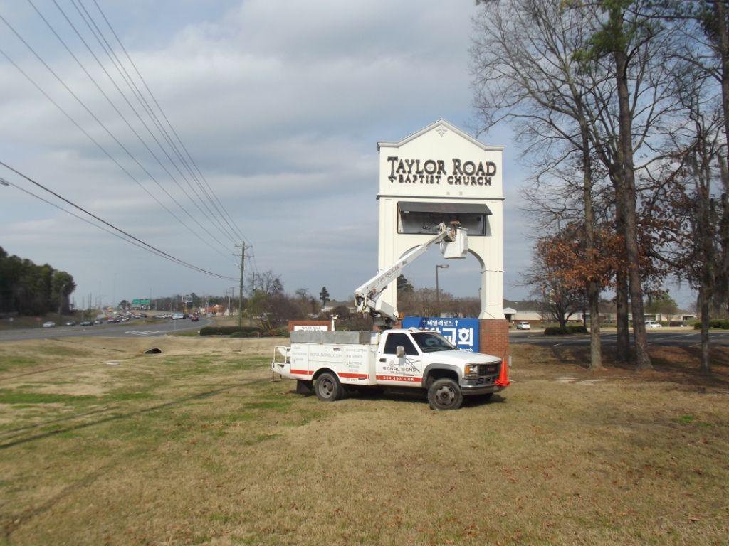 A white truck is parked in front of a sign that says taylor road