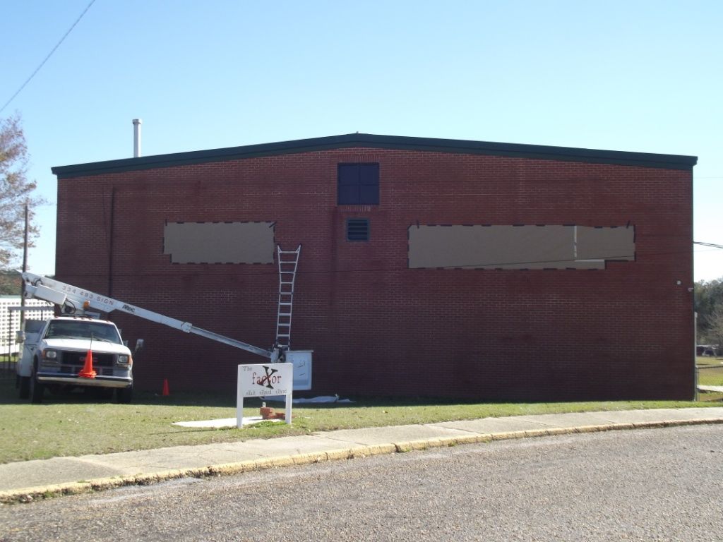 A white truck is parked in front of a large brick building