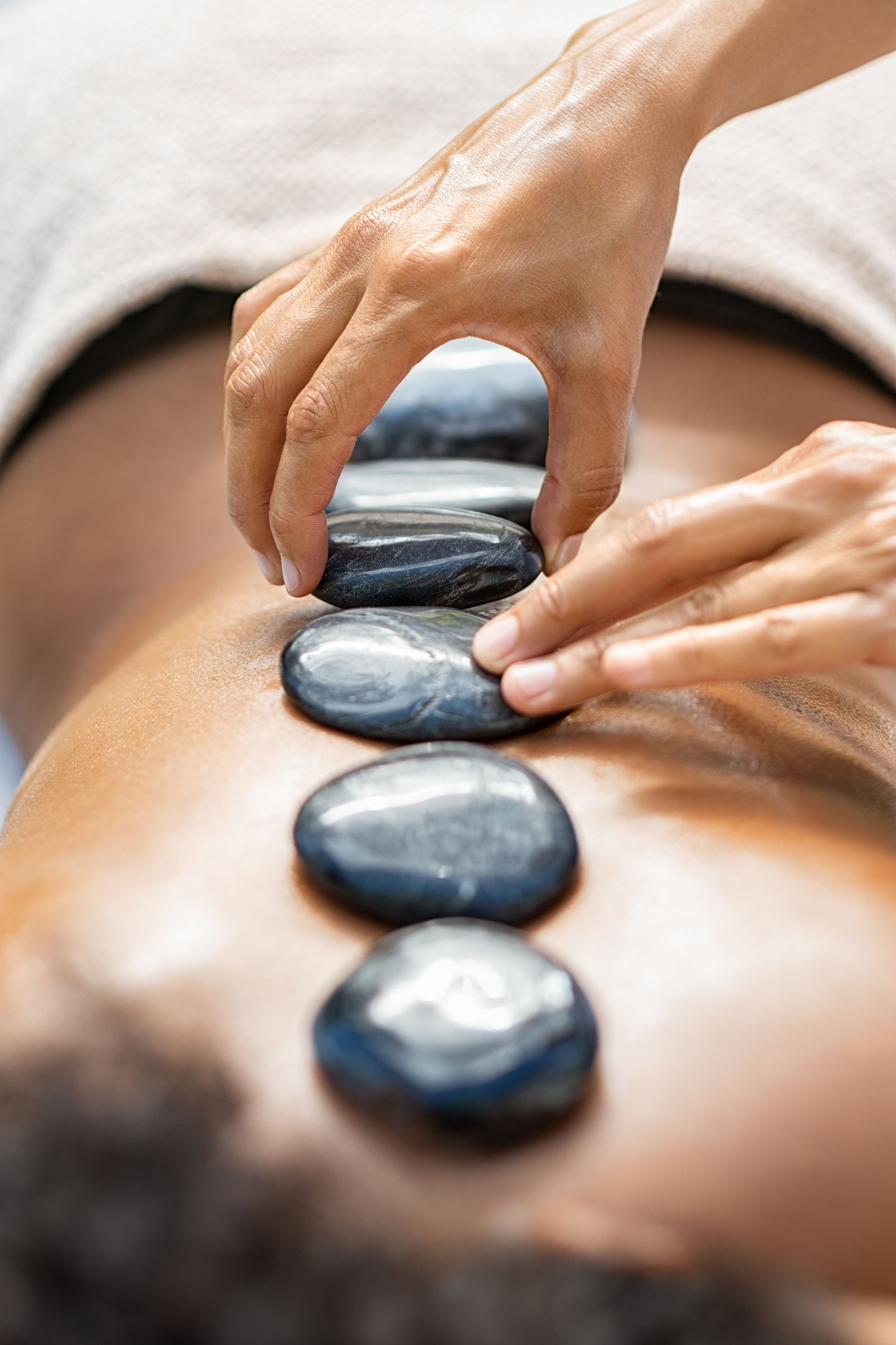 A woman is getting a hot stone massage at a spa.