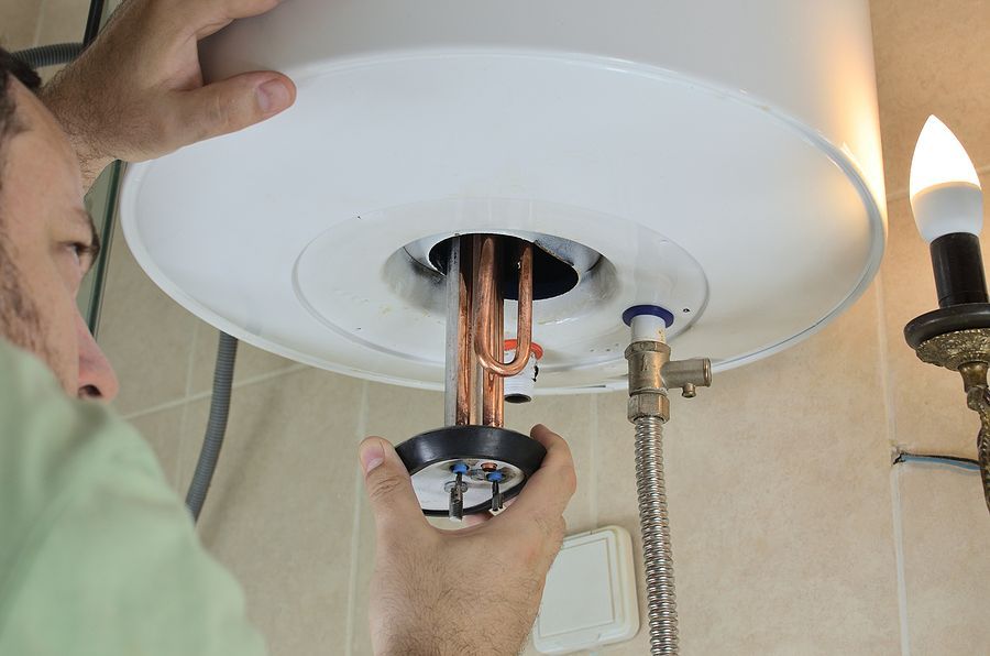 a man fixing a light fixture in a bathroom
