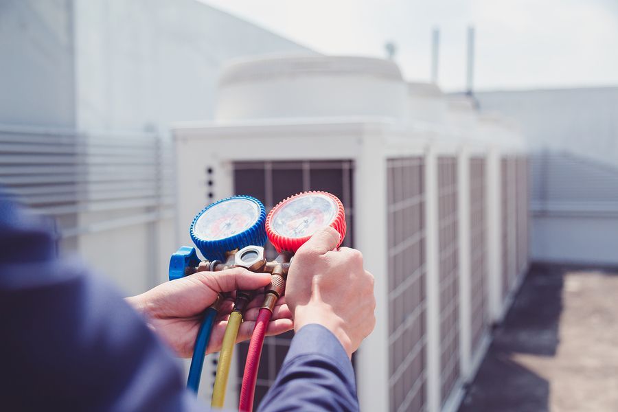 a man is checking the temperature of a air conditioner