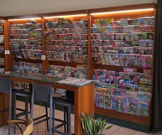 Un negozio pieno di riviste, un tavolo e delle sedie.