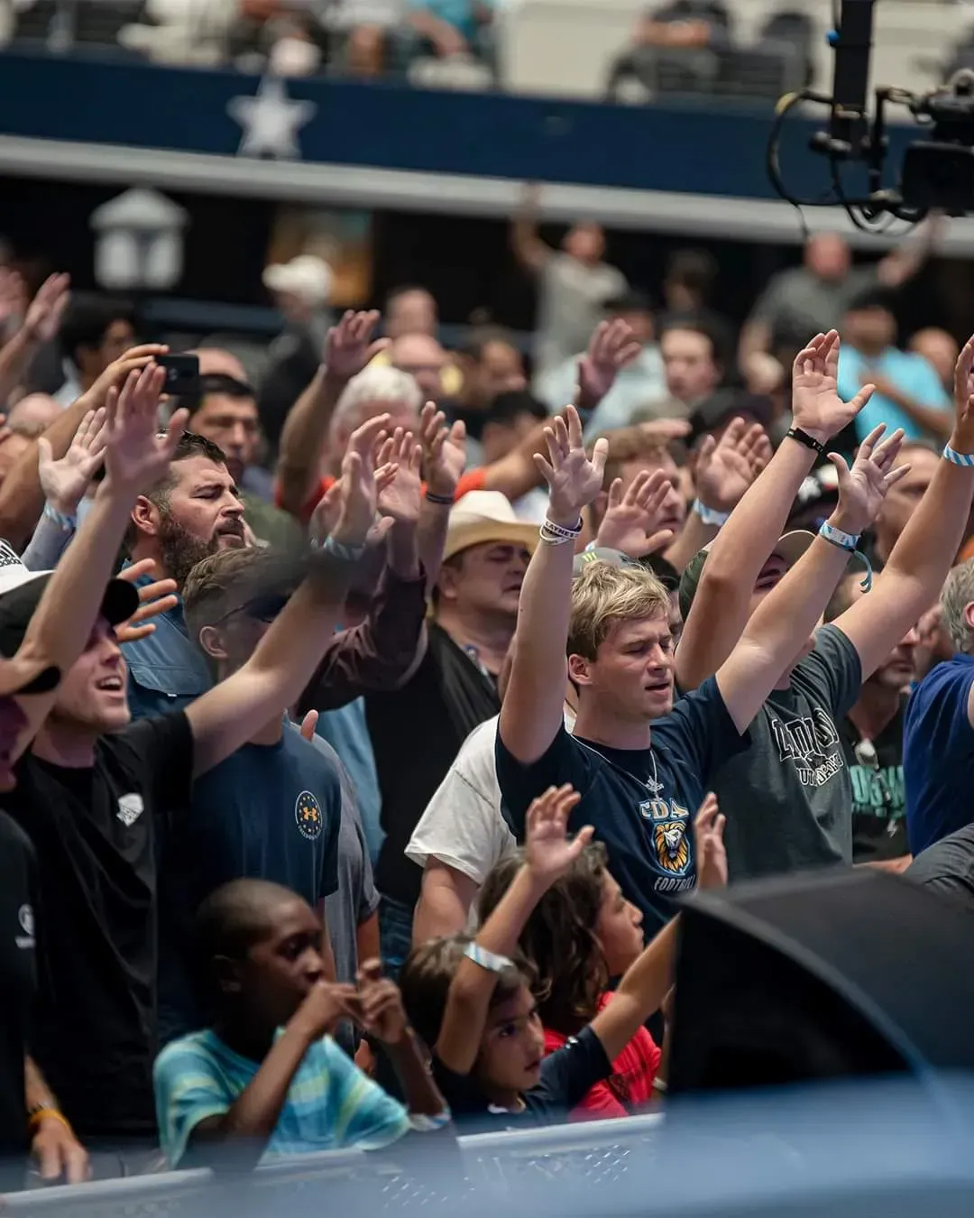 A crowd of people raising their hands in the air