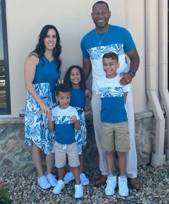 A family is posing for a picture in front of a building.