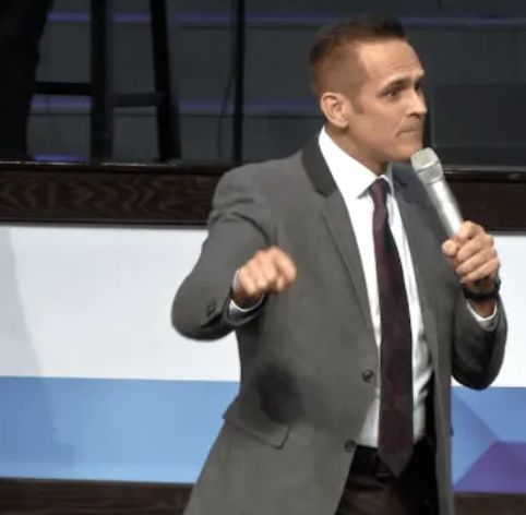 A man in a suit and tie is holding a microphone