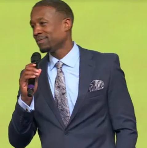 A man in a suit and tie is holding a microphone