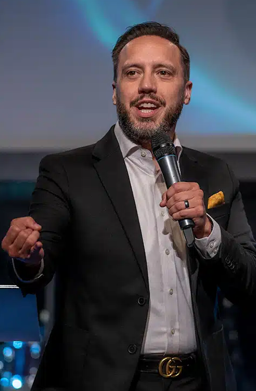 A man in a suit is holding a microphone in his hand.