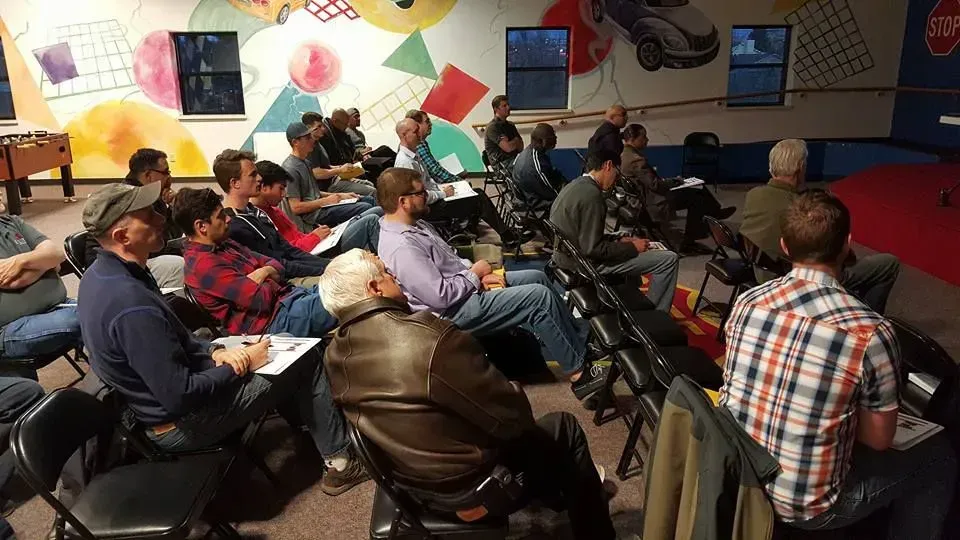 A group of people are sitting in chairs in a room.