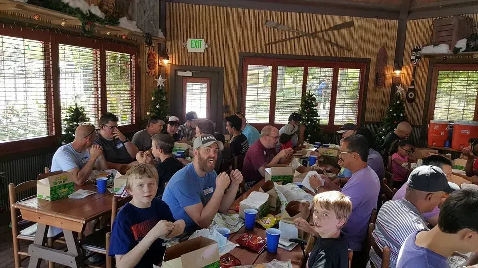 A group of people are sitting at tables in a restaurant eating food.