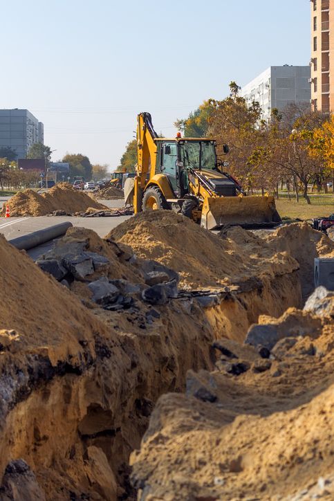 A bulldozer is digging a hole in the ground at a construction site.