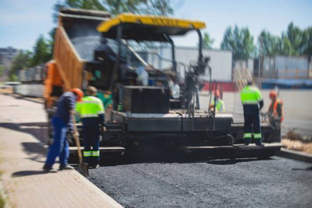 A group of construction workers are working on a road.