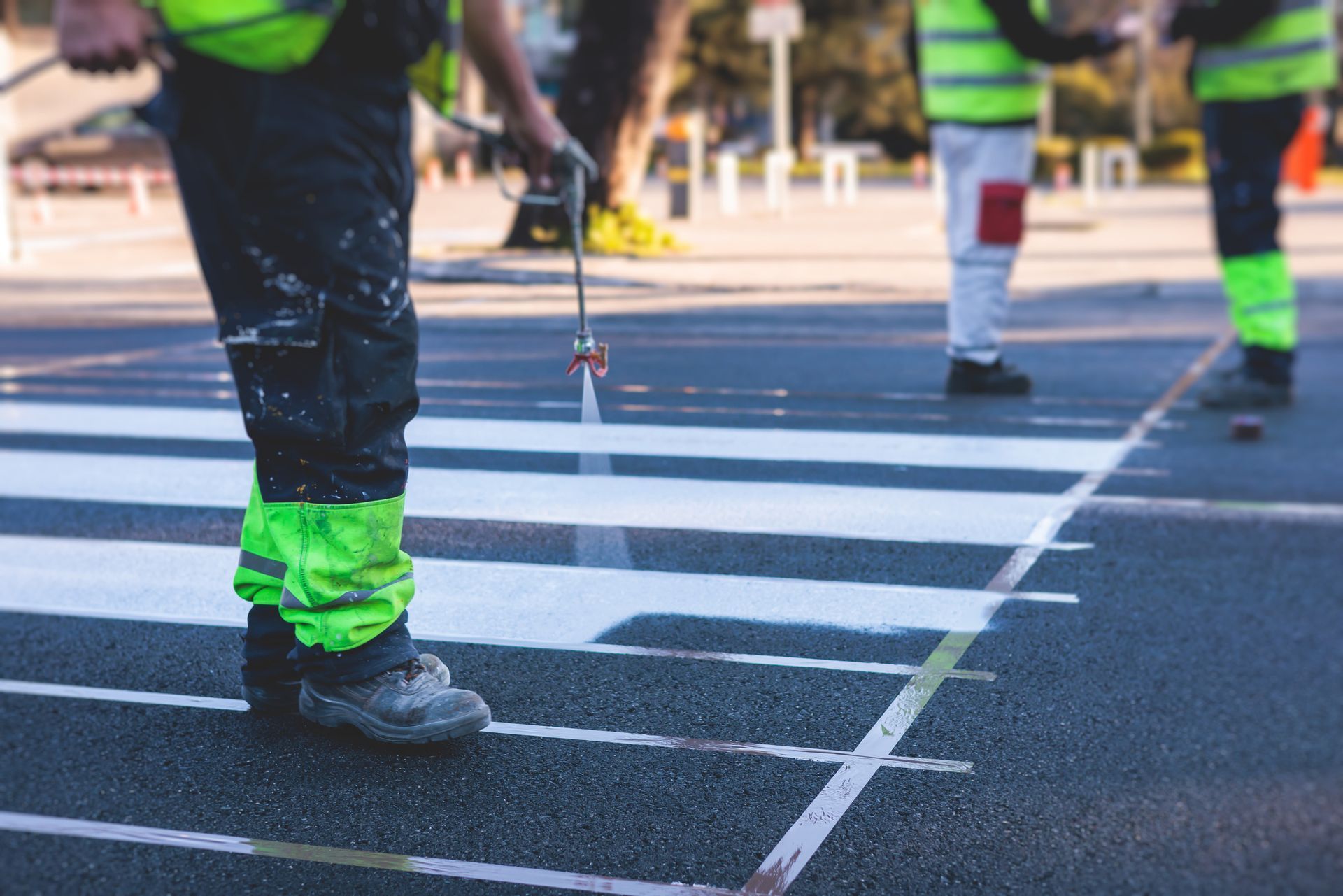 A group of people are painting a crosswalk on the road.