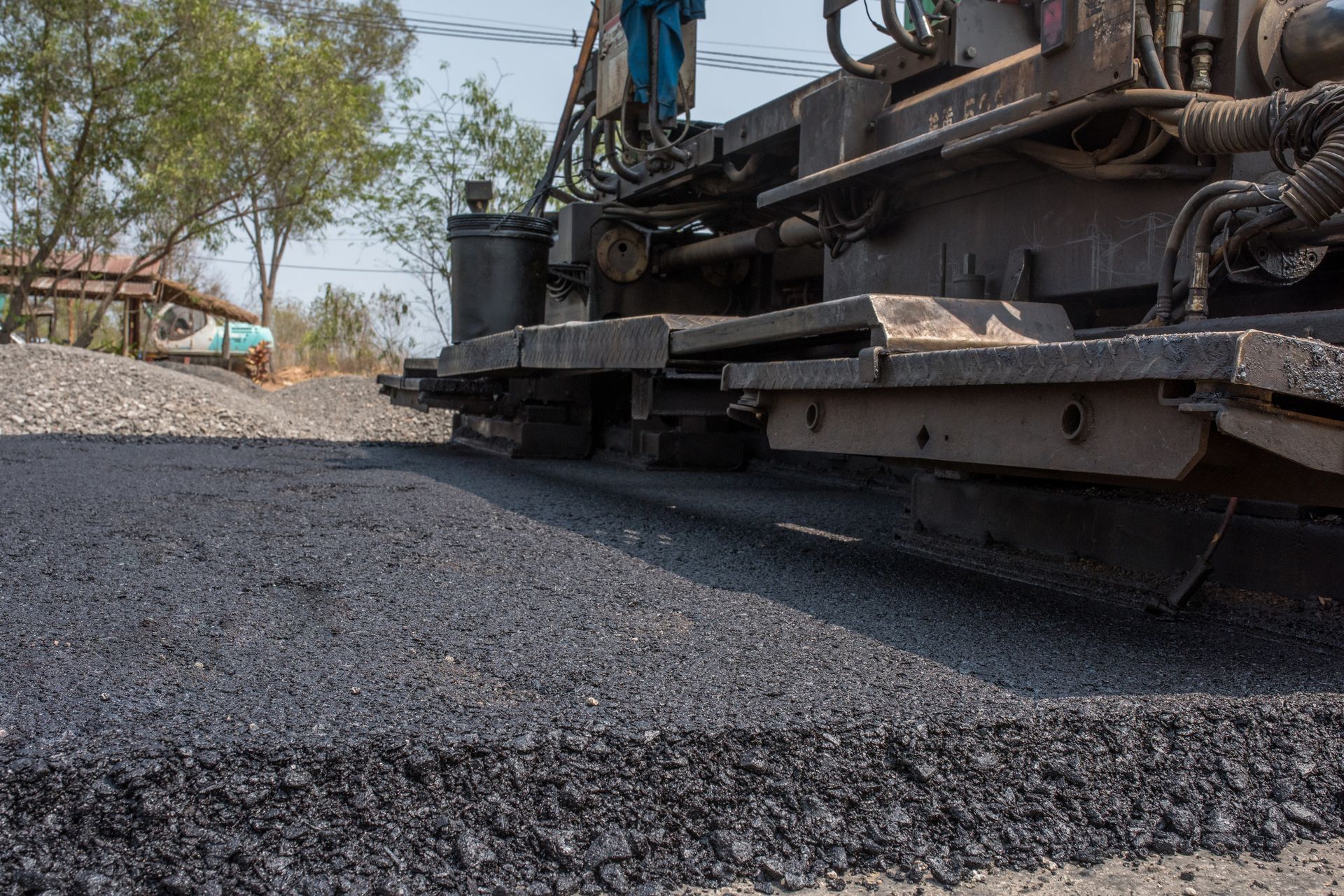 A machine is laying asphalt on a road.