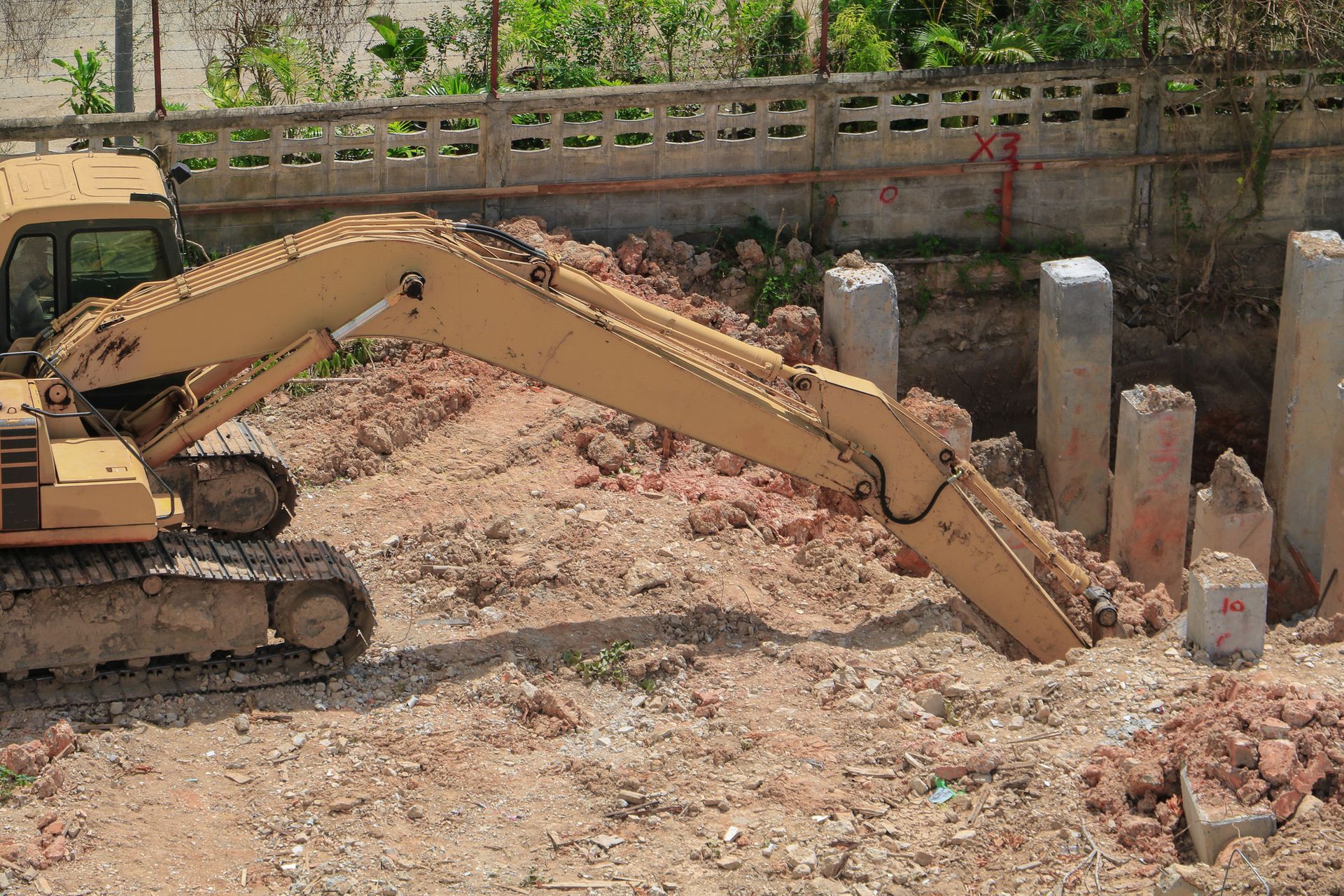 A large yellow excavator is working on a construction site.