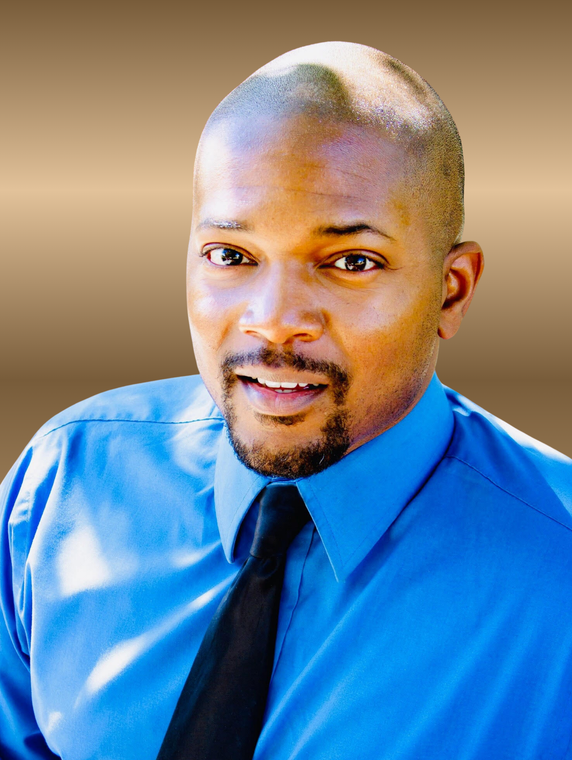 Man in blue shirt and black tie, looking towards the viewer with a slight smile.