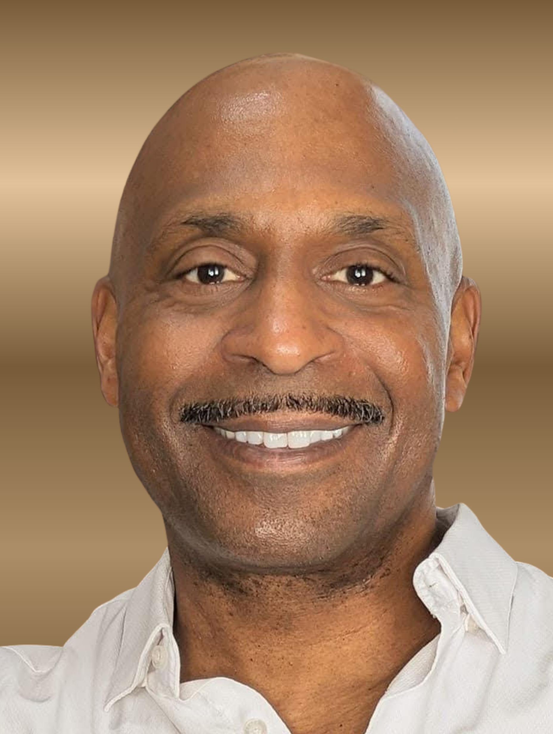 Man with a bald head and mustache, smiling at the camera. He wears a light-colored button-down shirt.