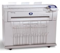 A large white printer is sitting on top of a white table.