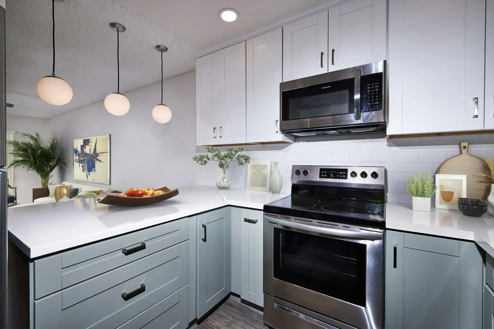 Modern kitchen with stainless steel appliances and light blue cabinetry.