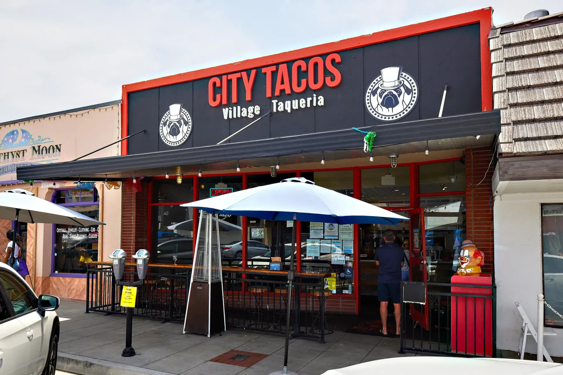 Exterior view of City Tacos restaurant with umbrellas and outdoor seating.