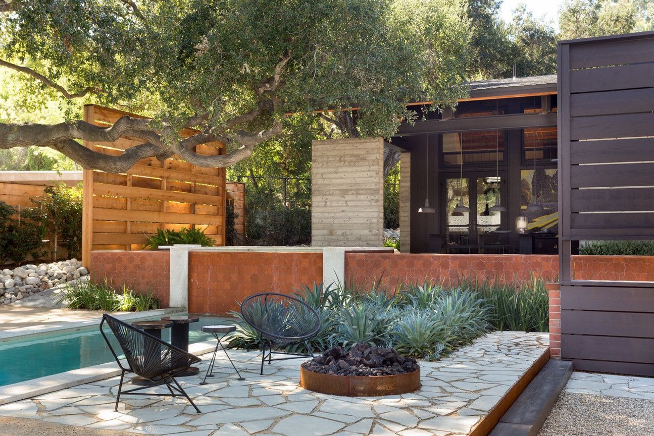 A patio with a table and chairs next to a pool.