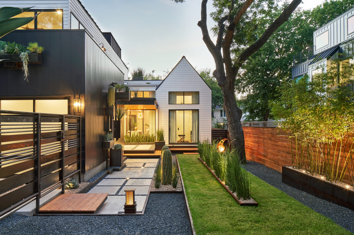 A modern house with a lush green lawn in front of it.