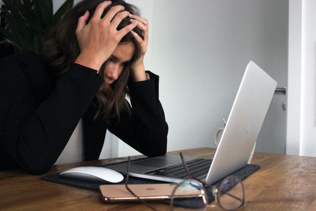 Stressed woman at computer. Photo by Elisa Ventur on Unsplash.