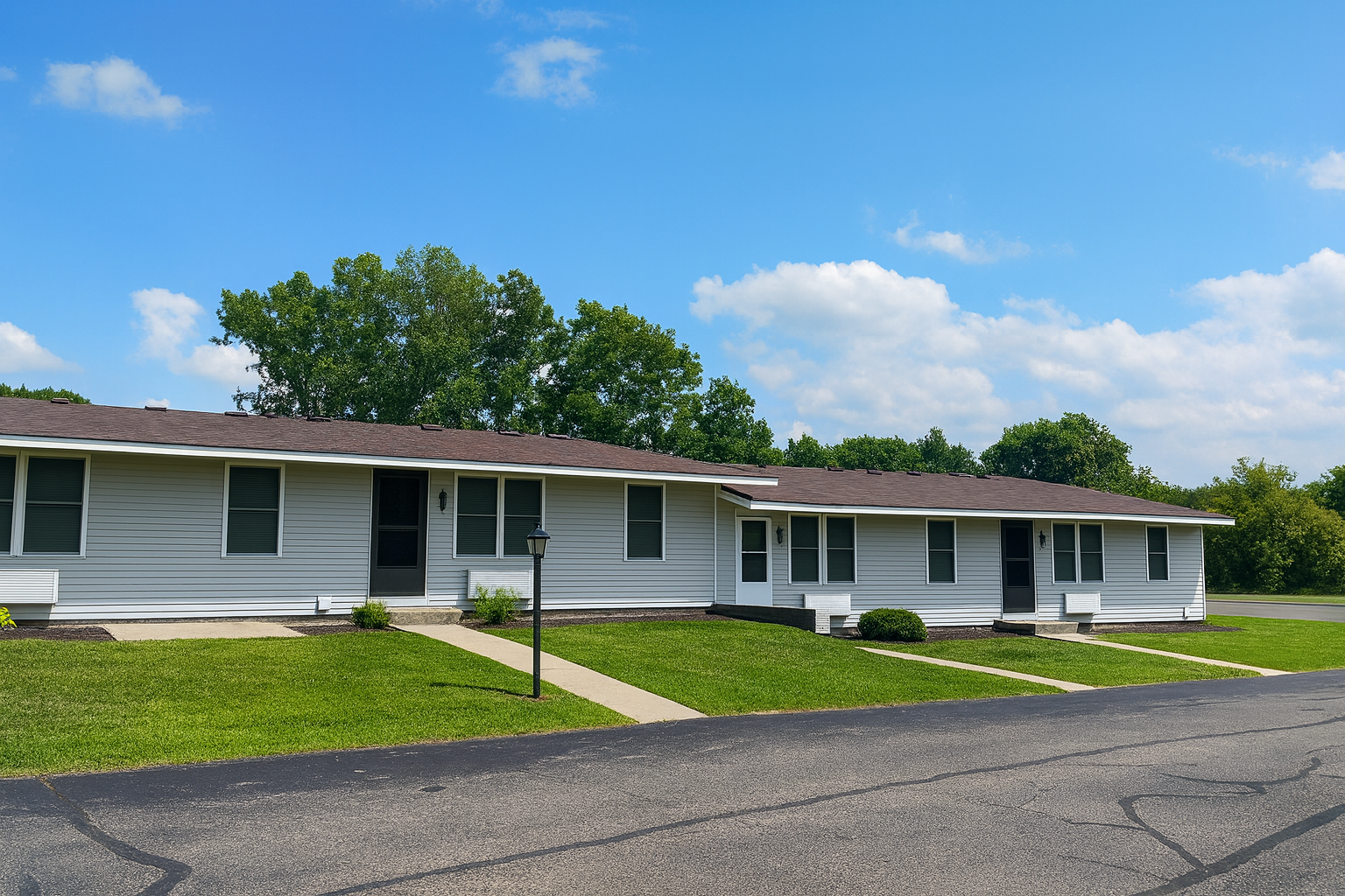 Photo of an apartment building with walkways from each front door heading  to the street