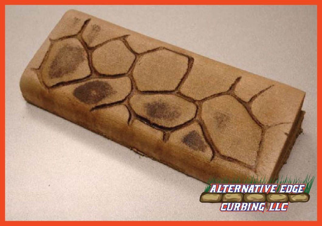 Stone-textured edging block in brown with dark accents, bearing the logo of 