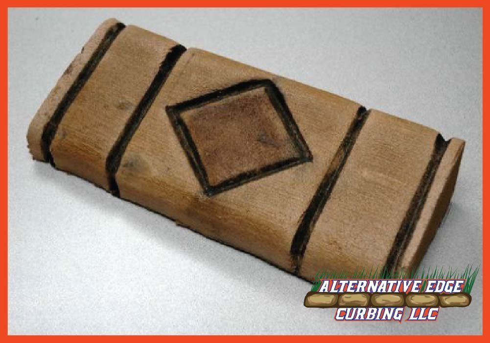 Brown wooden block with diamond design, used for curbing.