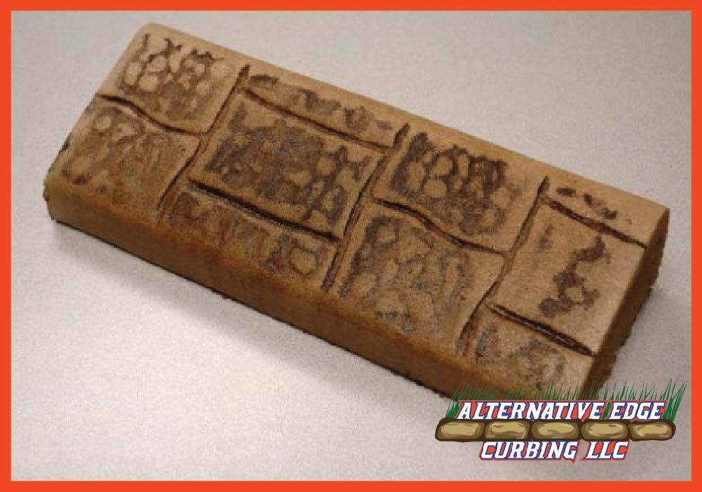 Brown concrete curbing with a stone pattern, a product of Alternative Edge Curbing LLC.