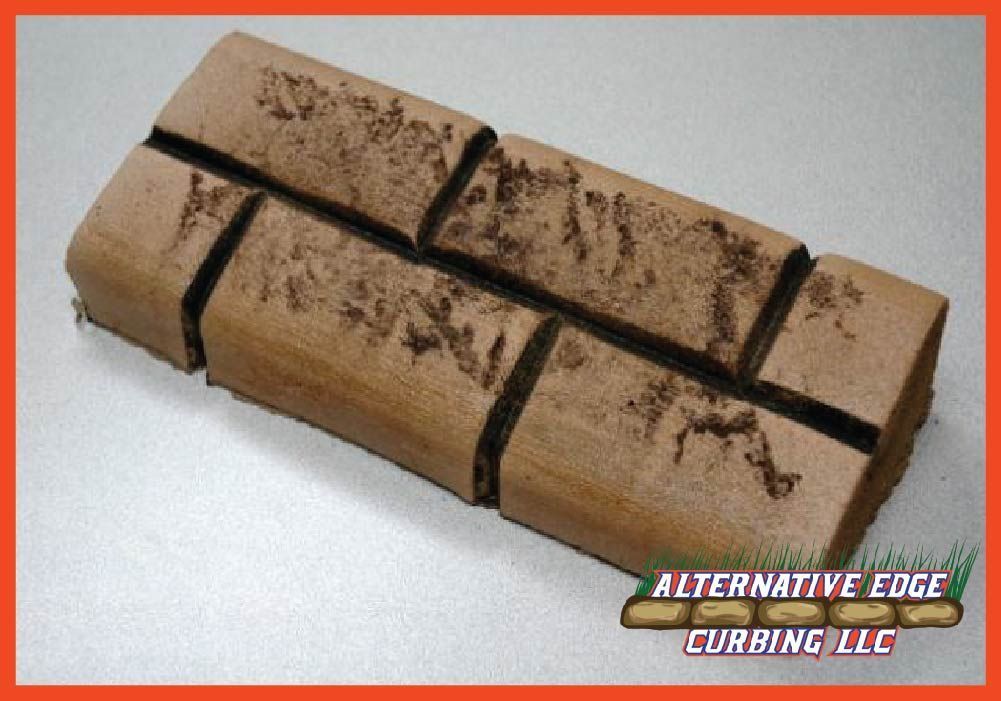 Brown, faux-brick landscaping curb with dark mortar lines on a light gray surface, logo visible.