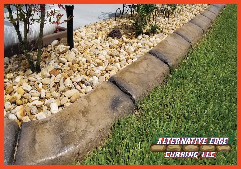 Concrete curbing separating gravel and grass with the logo of Alternative Edge Curbing LLC.