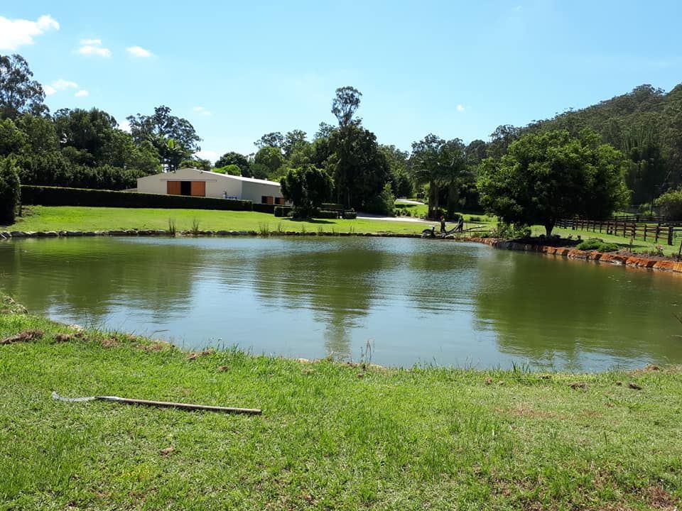 A Large Body Of Water With A House In The Background — Dams Cleaned in Gold Coast, QLD