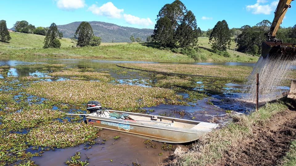 A Boat Is In The Middle Of A River — Dams Cleaned in Gold Coast, QLD