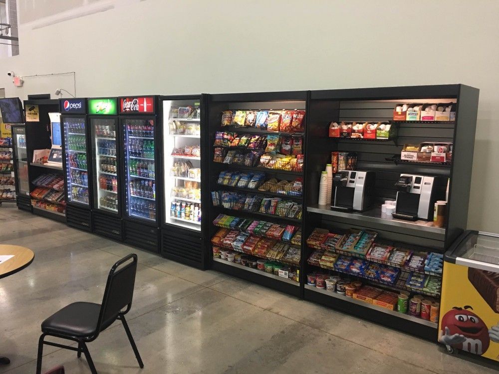 a row of vending machines are lined up next to each other in a store .