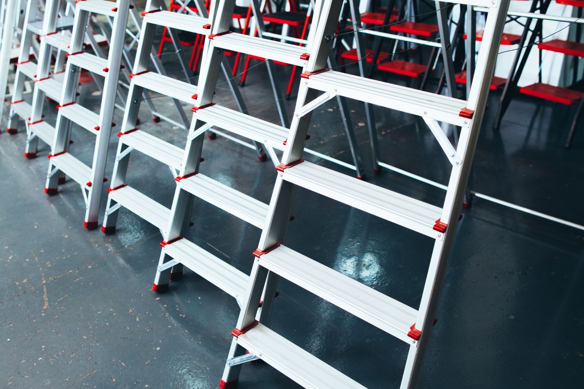 A row of ladders are lined up in a room.