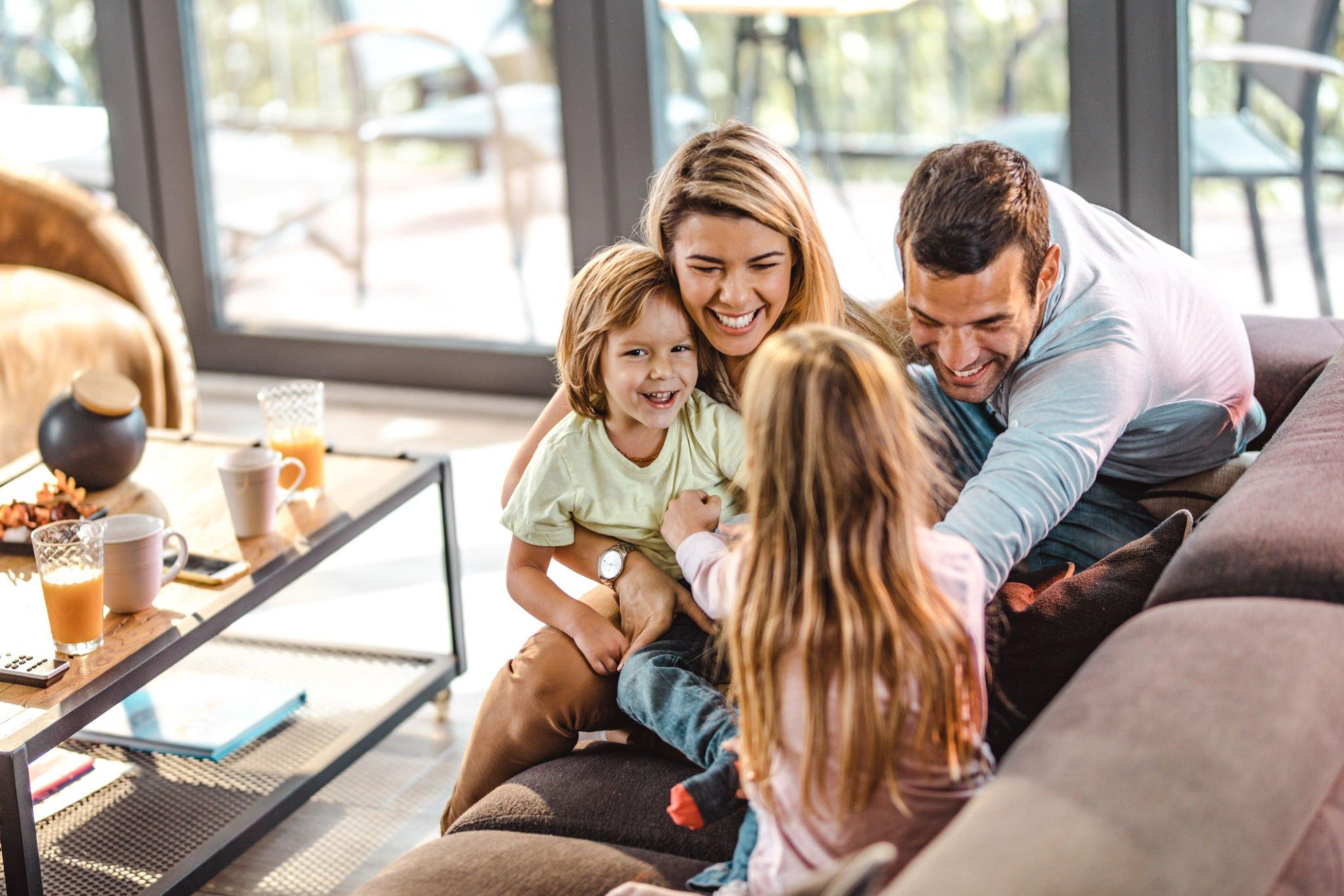 A family is sitting on a couch in a living room.