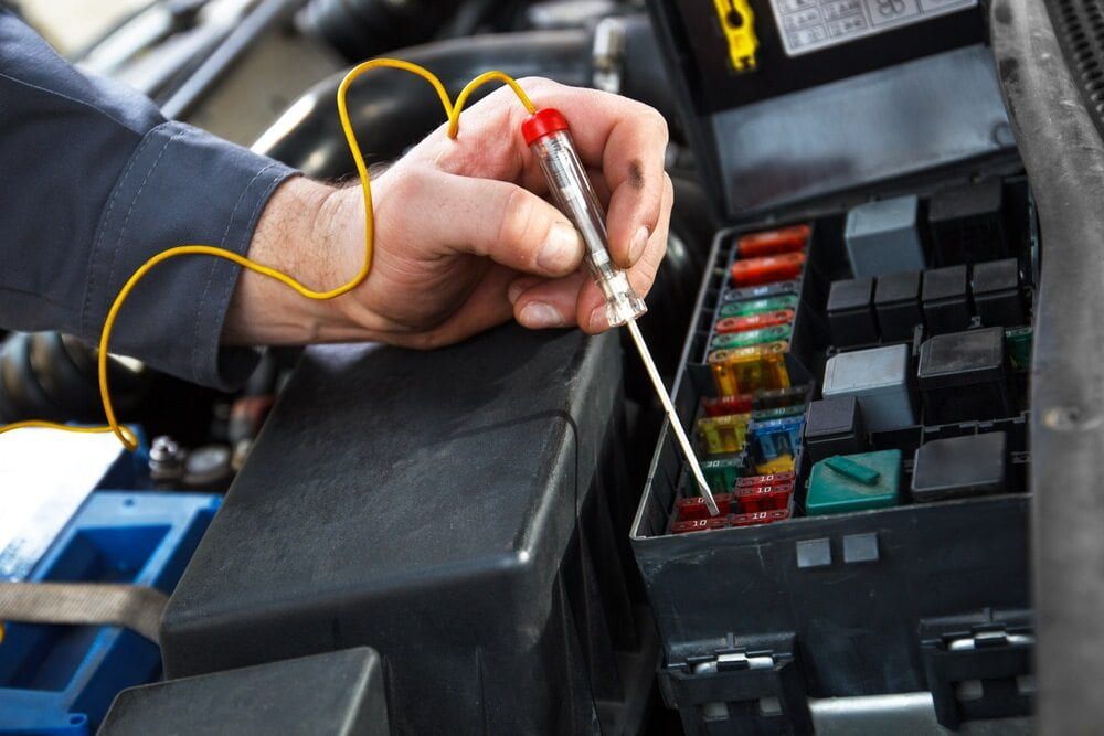 A Person is Working on a Fuse Box With a Screwdriver — Quick Fix Automotive in Ballina, NSW