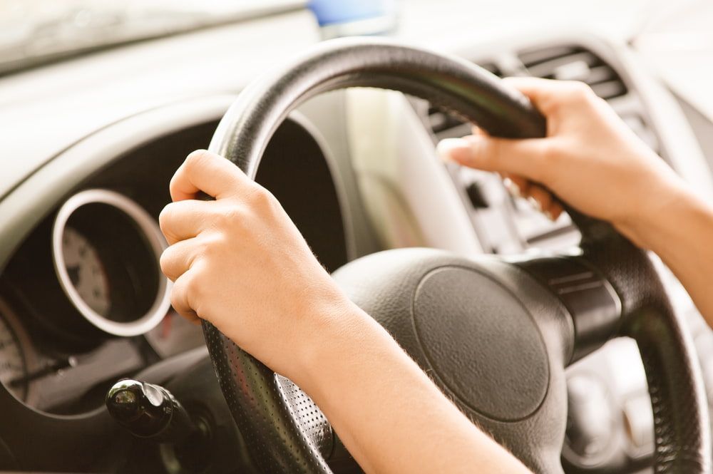 A Person is Holding the Steering Wheel of a Car — Quick Fix Automotive in Ballina, NSW