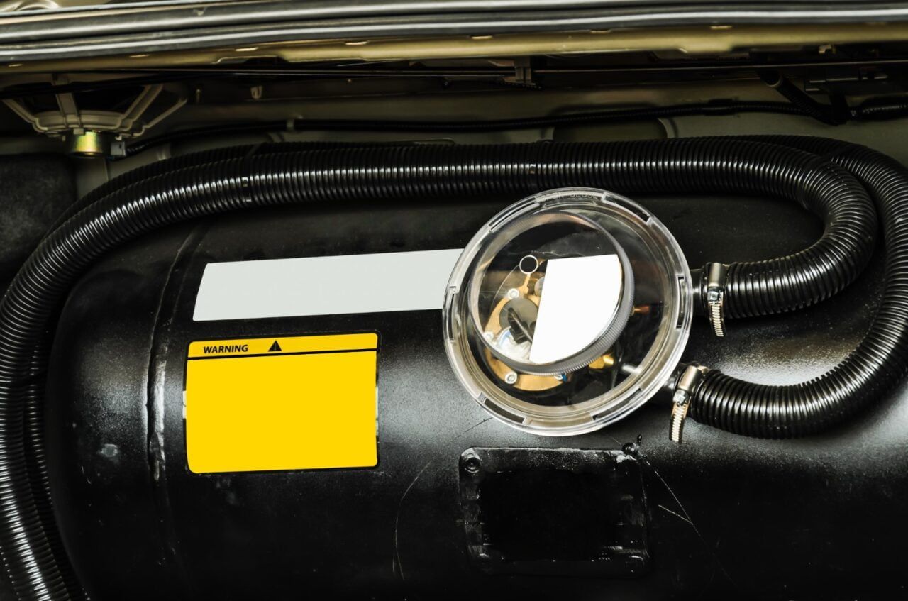Black Tank With Yellow Labels, Reflective Mirror, and Black Hose — Autopro Taree in Taree, NSW