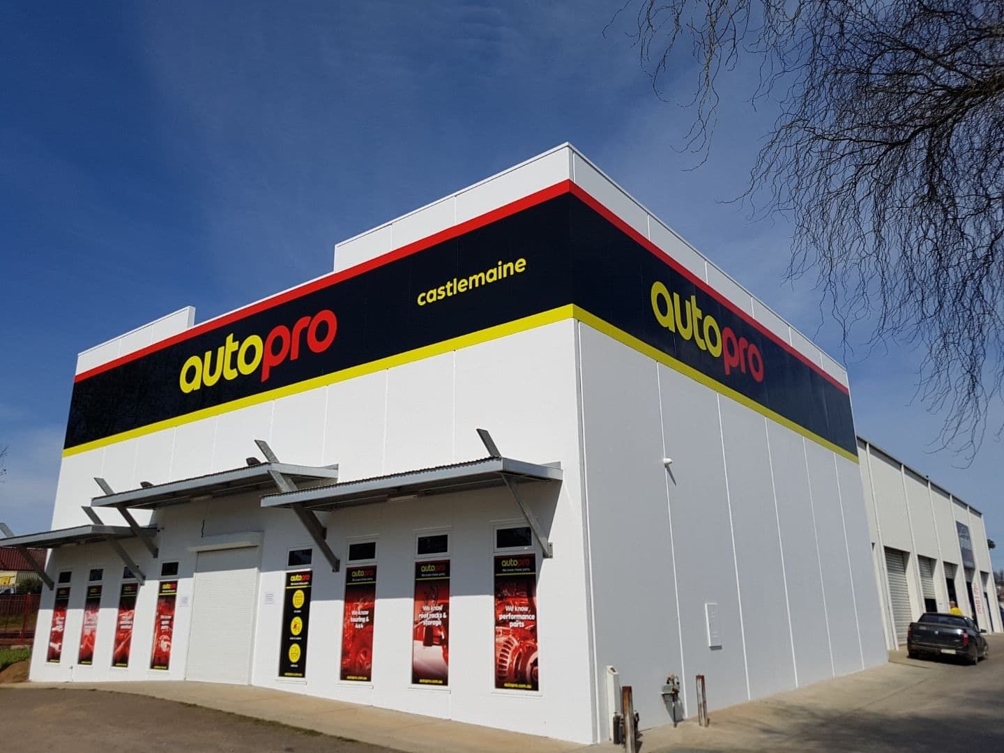 Autopro Automotive Store, White Building With Yellow/red Logo on a Sunny Day — Autopro Taree in Taree, NSW