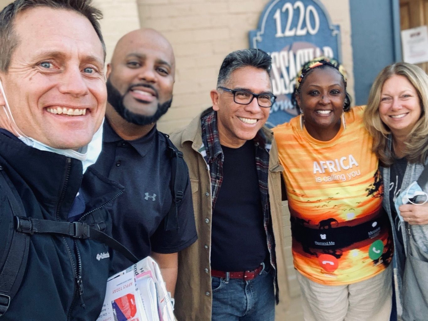 A group of people posing for a picture in front of a sign